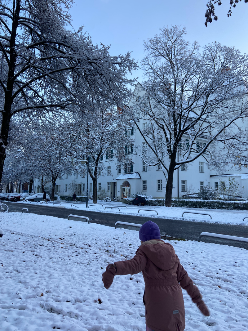 Kind in warmer Winterkleidung spielt im Schnee