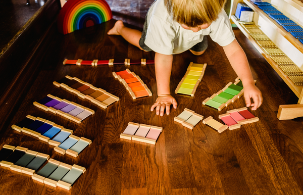 Kind sortiert buntes Montessori Spielzeug