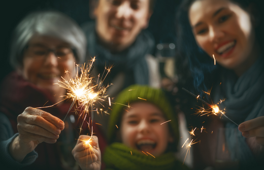 Familie hat Spaß mit Wunderkerzen an Silvester