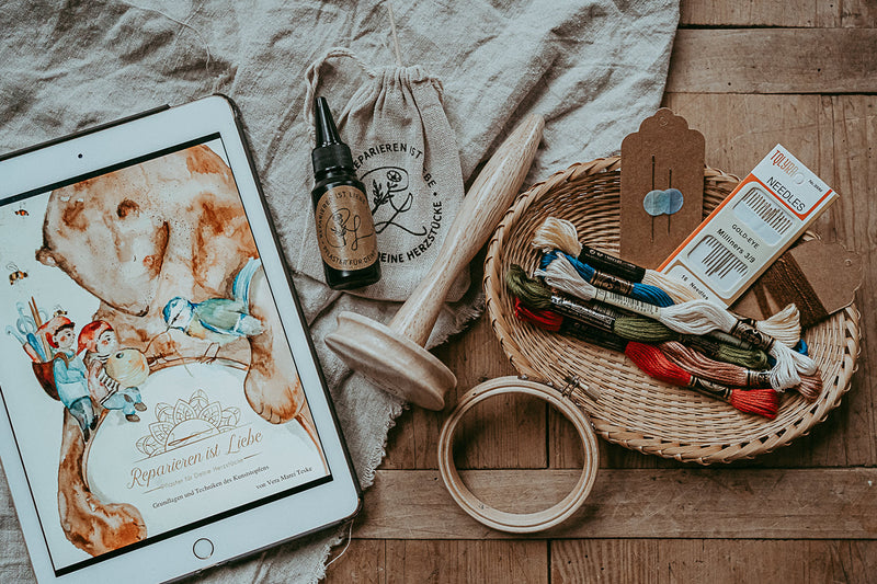 Ein gesamtes Textil Reparatur Startbereit auf dem Tisch. Nadel, Stickrahmen, Stoffe