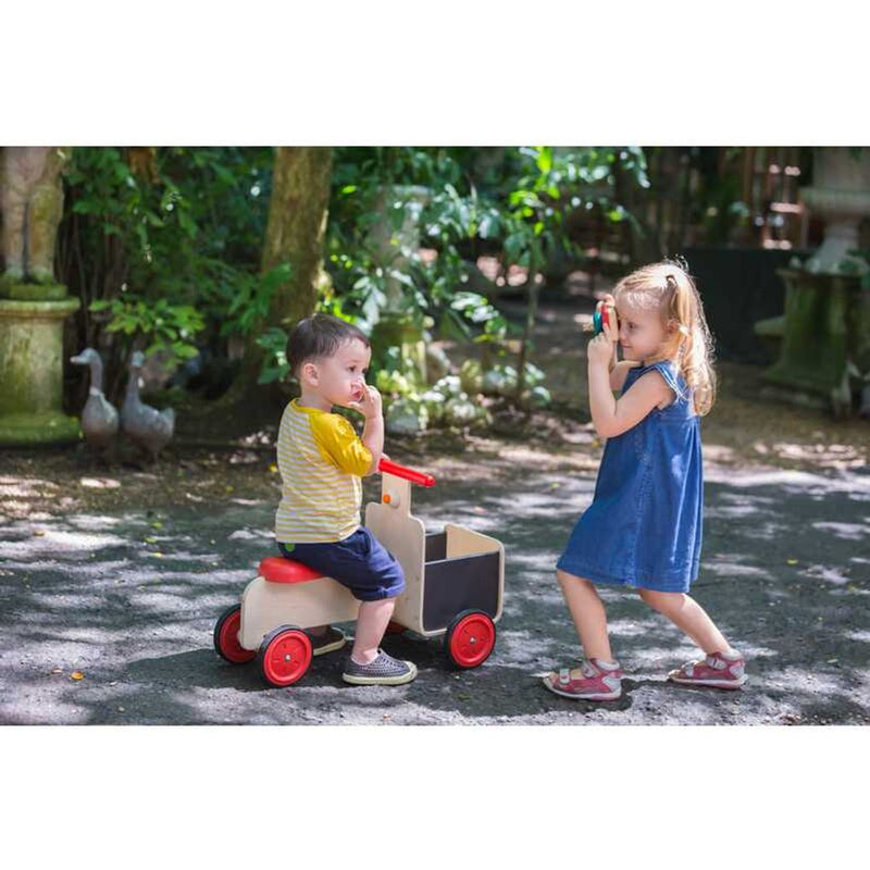 Kid playing PlanToys Delivery Bike