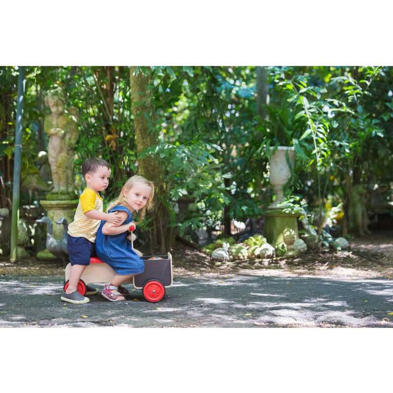 Kid playing PlanToys Delivery Bike