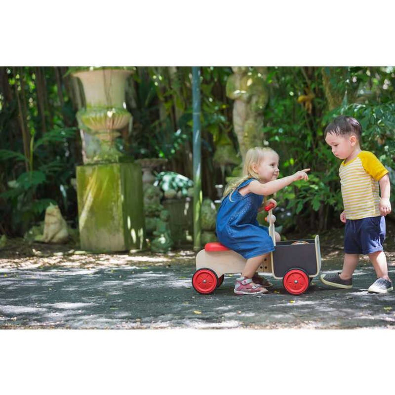 Kid playing PlanToys Delivery Bike