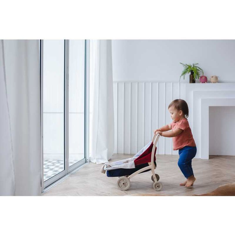 Kid playing PlanToys Doll Stroller