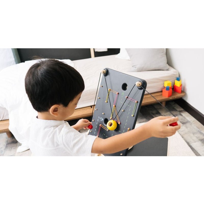 Kid playing PlanToys Wall Ball Game