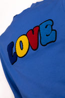 Detailansicht: Hochwertige 3D-Stickerei der LOVE Signature – Ein täglicher Reminder: There can never be enough love – Hochwertige Verarbeitung auf Bio-Baumwolle – Close-up LOVE embroidery detail – Never enough love – Détail de broderie LOVE de haute qualité.