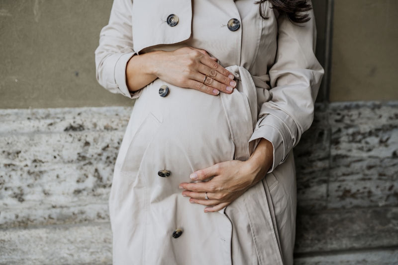 Nahaufnahme Babybauch Umstands-Trenchcoat mieten