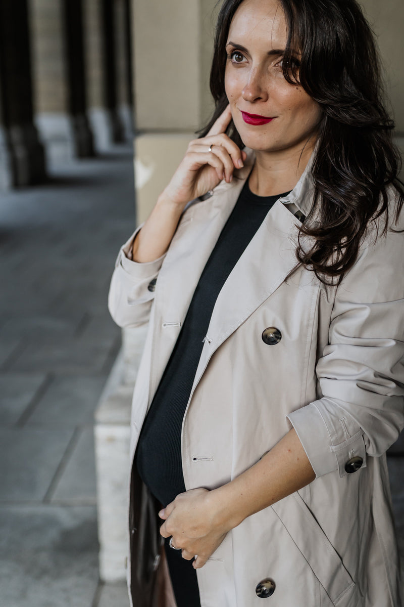 Schwangere Frau trägt Umstands-Trenchcoat beige