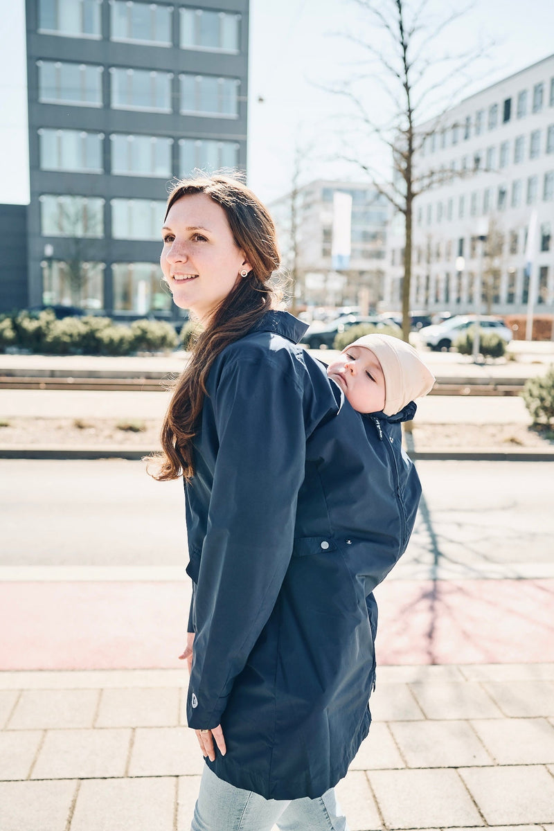 Frau mit Tragejacke marineblau und Baby am Rücken