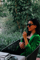 Schwangere Frau mit dunklen Haaren und grünem Blazer