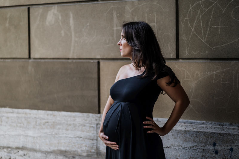 Nahaufnahme one-shoulder Cocktailkleid für Schwangere schwarz. offene Haare