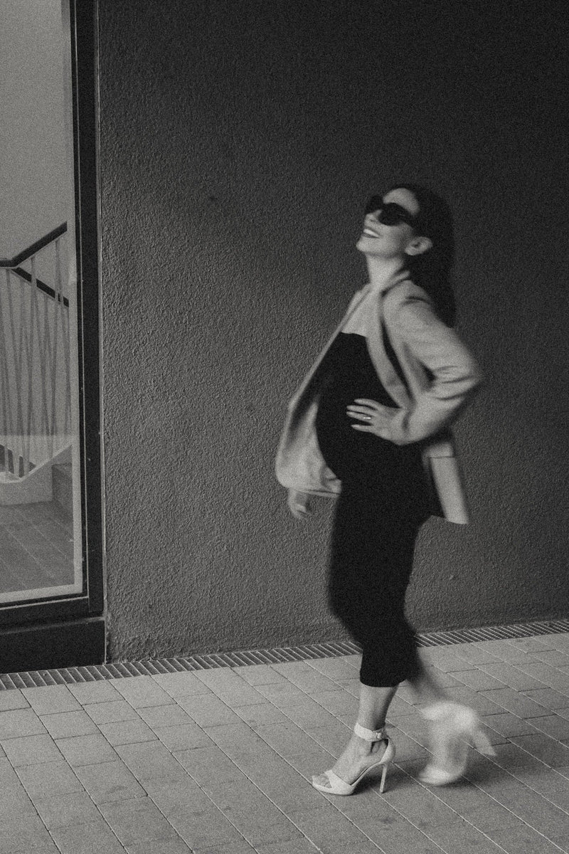 Schwarz-weiß Aufnahme schwangere Frau im Umstandskleid und Umstandsjacke