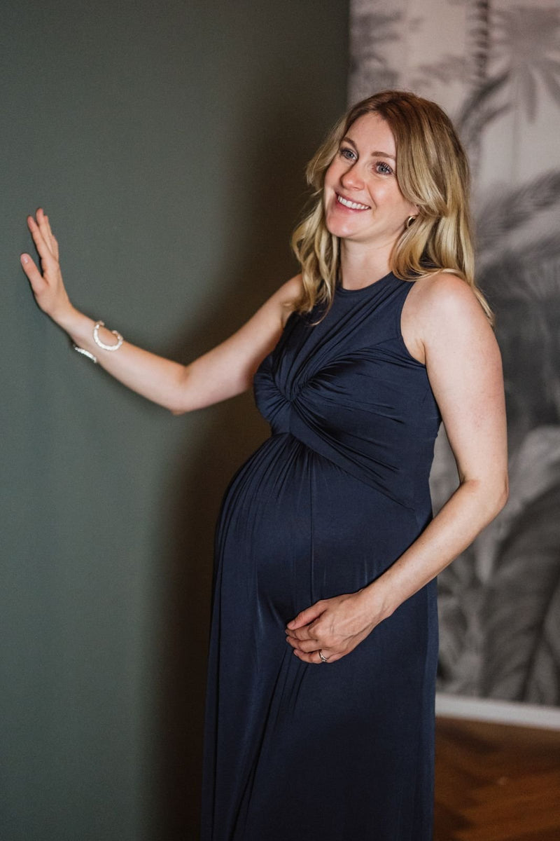 Blonde Frau im Schwangerschaftskleid navy
