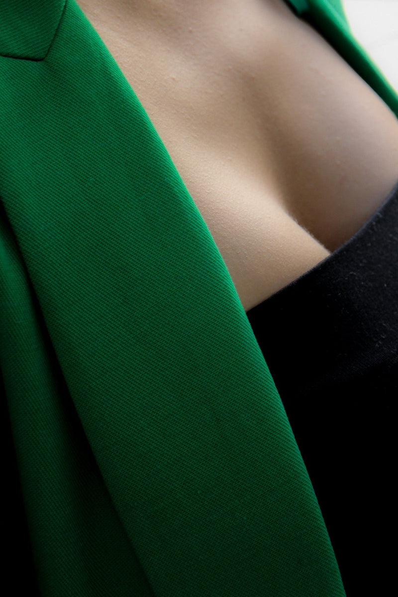 De­kolle­té schwangere Frau mit gruenem Blazer